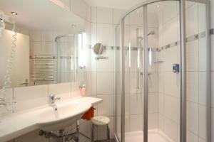 a white bathroom with a sink and a shower at Appartements Feehof in Saas-Fee