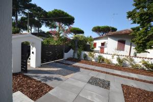 a garden with a black gate and a house at SIT Holiday Homes in Lido delle Nazioni