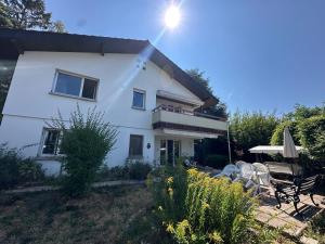 a white house with a patio and an umbrella at Villa Lake View in Grandvaux