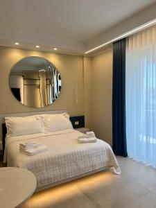 a bedroom with a large bed and a round mirror at Manoli Luxury Rooms in Vieste +55 photos