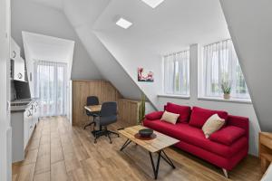 a living room with a red couch and a table at AJO Apartments - Vetmed - Self-Check-in in Vienna