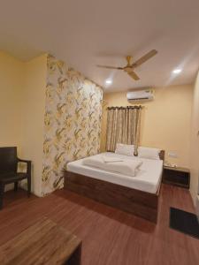 a bedroom with a bed and a ceiling fan at Hotel Royal Palace in Kolkata