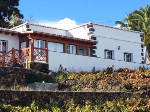 a white house with a stone wall at Casa el Durazno in Lodero