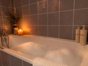 a bath tub with bubbles in it with candles at Côté green in Juvignac