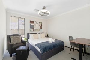 a bedroom with a bed and a desk and a chair at Drift at Shorehaven Coast in Alkimos