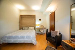 a bedroom with a bed and a chair and a desk at Travessa in Lisbon