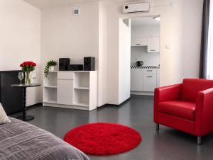 a bedroom with a red chair and a red rug at Sercowe Zacisze in Chełmża