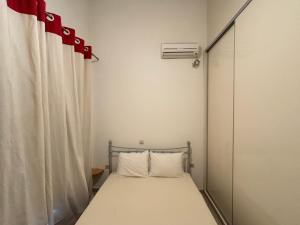 a small bedroom with a bed and a window at The Old Winery in Aliveri