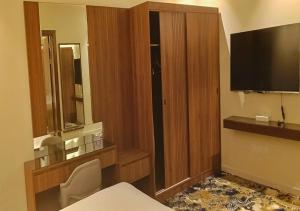 a hotel room with a television and a desk with a chair at المهاجر للشقق المخدومة بالكورنيش in Jeddah +44 photos