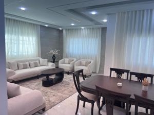 a living room with couches and a table and chairs at Ali Building in Wadi Musa