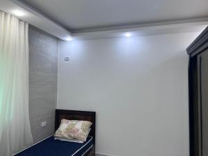 a bed in a room with a white wall at Ali Building in Wadi Musa