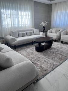 a living room with white couches and a coffee table at Ali Building in Wadi Musa