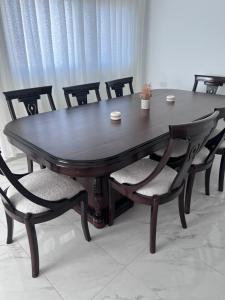 a dining room table with chairs and a wooden table with at Ali Building in Wadi Musa