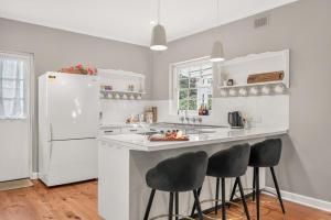 a white kitchen with a white refrigerator and stools at The Retreat, Barossa Valley in Lights Pass +22 photos