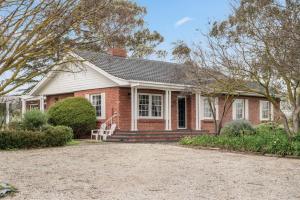 a red brick house with a porch and a yard at The Retreat, Barossa Valley in Lights Pass