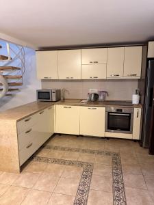 a kitchen with white cabinets and a stove top oven at Vila Srna in Petrovac na Moru