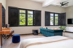 a bedroom with a blue couch and windows at The Oliver Hotel - Adults Only in San Juan