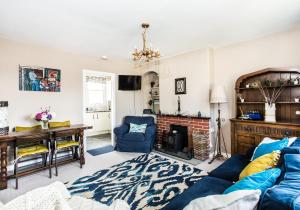 a living room with a blue couch and a fireplace at Lynn Cottage in East Linton
