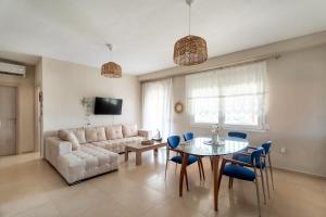 a living room with a couch and a table and chairs at Sunset Luxury Potidea in Metókhion Patriotikón