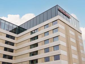 an office building with a hotel sign on top at Mövenpick Hotel Brussels Airport in Zaventem