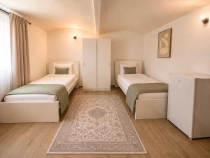 a bedroom with two beds and a rug at Urban Base CELJE in Celje