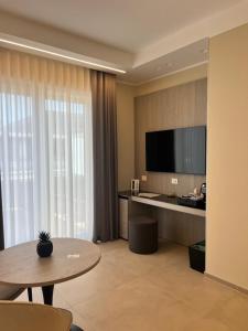 a hotel room with a table and a large screen television at Manoli Luxury Rooms in Vieste