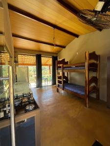 a living room with bunk beds and a kitchen at Chale3 Rabodegalo in Santana do Riacho