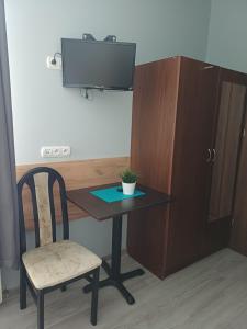 a desk with a chair and a tv on a wall at Santa Maria in Kołobrzeg