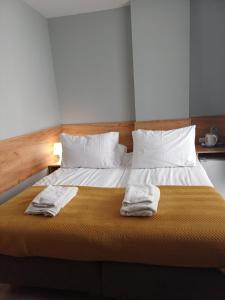 a bedroom with a bed with two towels on it at Santa Maria in Kołobrzeg