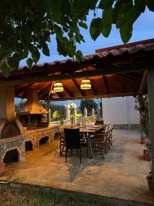 an outdoor patio with a table and a fireplace at Sunset Luxury Potidea in Metókhion Patriotikón