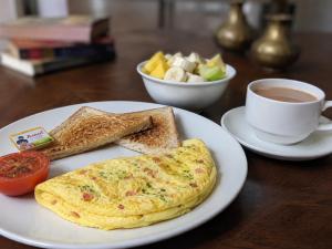 a omelet on a plate with toast and a cup of coffee at Urbanest B&B in Shillong
