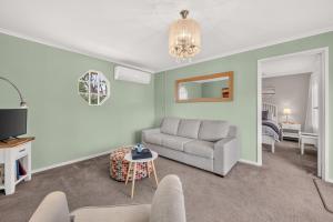 a living room with a couch and a table at Grace Cottage, Barossa Valley in Lights Pass