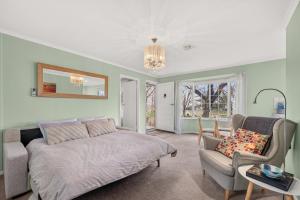 a bedroom with a bed and a couch and a chair at Grace Cottage, Barossa Valley in Lights Pass