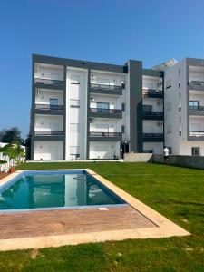a building with a swimming pool in front of a building at Horizon yasmine in Yasmine