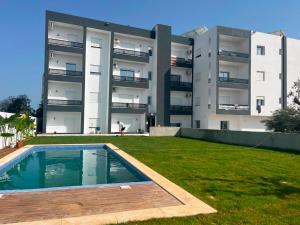 an apartment building with a swimming pool in front of it at Horizon yasmine in Yasmine
