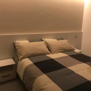 ein Schlafzimmer mit einem Bett mit einer schwarzen und weißen Decke in der Unterkunft Bed&Cappuccini in Avellino