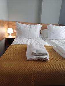 a bed with two towels sitting on top of it at Santa Maria in Kołobrzeg