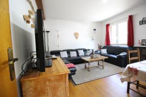 a living room with a flat screen tv on a dresser at Le Gite 5 mn de Luchon - Jardin garage et parking in Benque-Dessous-et-Dessus