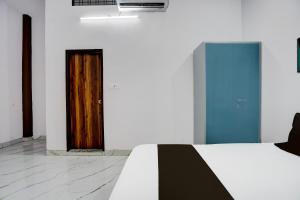a room with a bed and a wooden door at HOTEL O VIP HILL HOMESTAY in Mājra