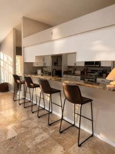 a row of chairs sitting at a bar in a kitchen at Desert Disconnect Pool and Putting Green in Gilbert