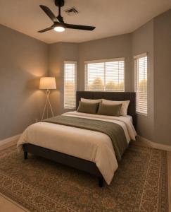 a bedroom with a large bed with a ceiling fan at Desert Disconnect Pool and Putting Green in Gilbert +9 photos