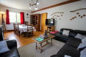 a living room with a couch and a table at Le Gite 5 mn de Luchon - Jardin garage et parking in Benque-Dessous-et-Dessus