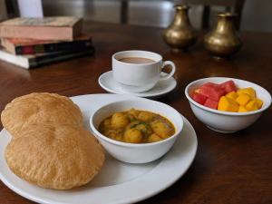 a table with a plate of food and a cup of coffee at Urbanest B&B in Shillong +27 photos
