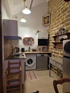 a kitchen with a washing machine and a stove at A La Maison in Les Repôts