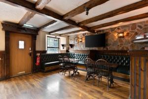 a room with a table and chairs and a tv at The Tavern in Buchlyvie