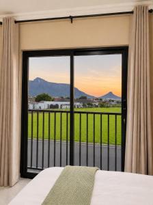 a bedroom with a bed and a large glass window at Jets Stay Property in Cape Town