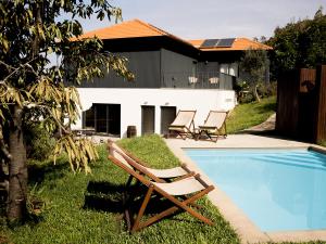 a couple of lounge chairs next to a swimming pool at Cimo da Vinha - Nature Spot in Castelo de Paiva