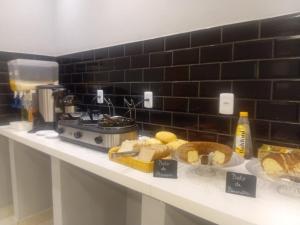 a counter with bread and other foods on it at Unity Hotel - Allianz SP in São Paulo