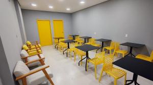 a row of tables and chairs in a room with yellow doors at Unity Hotel - Allianz SP in São Paulo