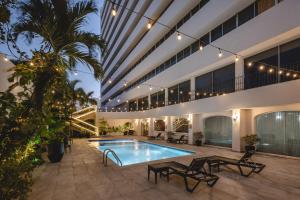 an indoor courtyard with a swimming pool and a building at Gamma Merida El Castellano in Mérida
